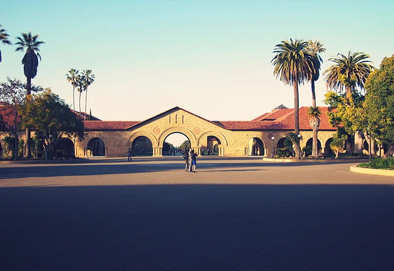 Arcades en grès du Main Quad de l'université Stanford bordées de palmiers