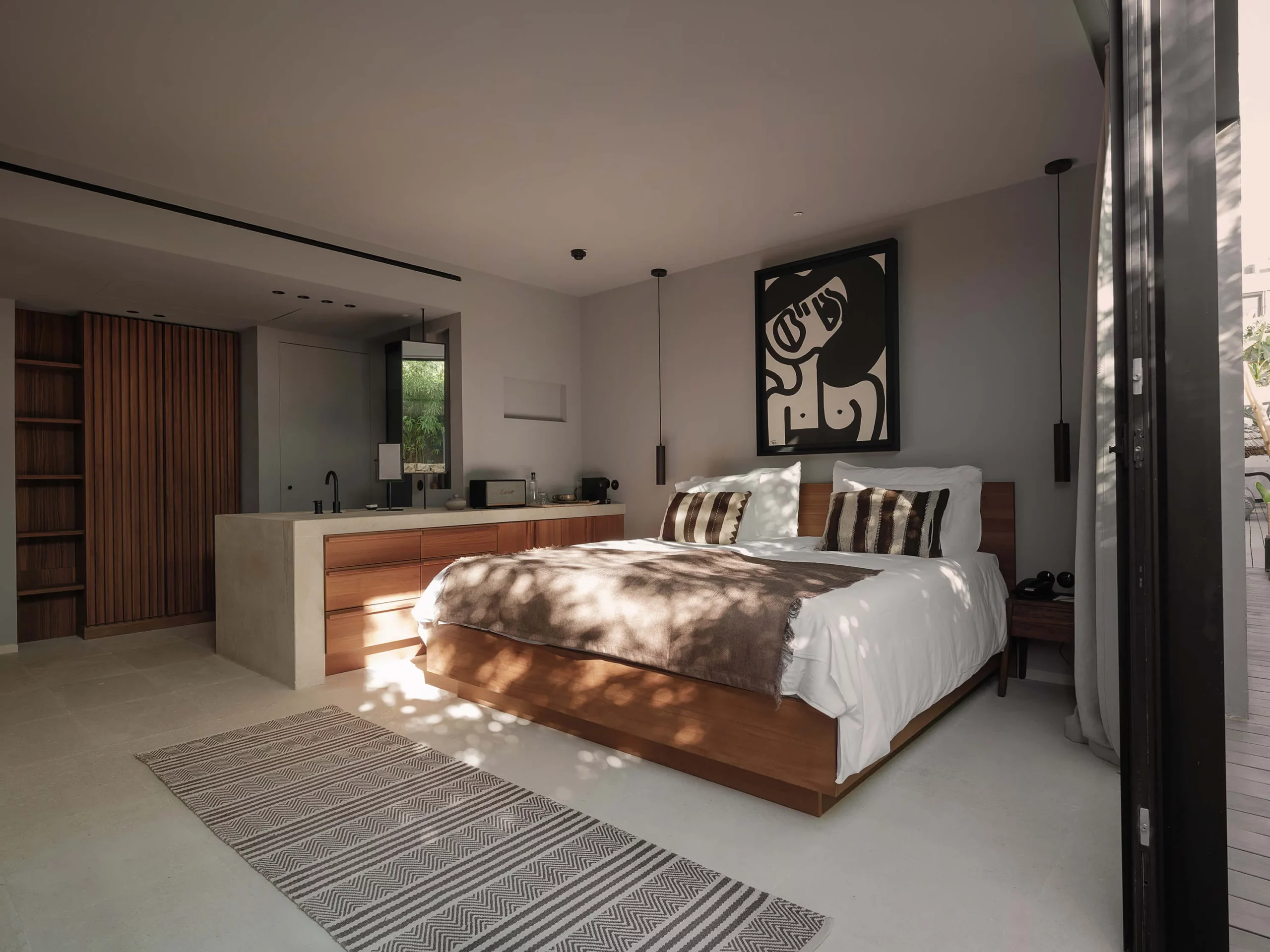 Chambre épurée au lit en bois et murs beige de l'hôtel OKU Ibiza