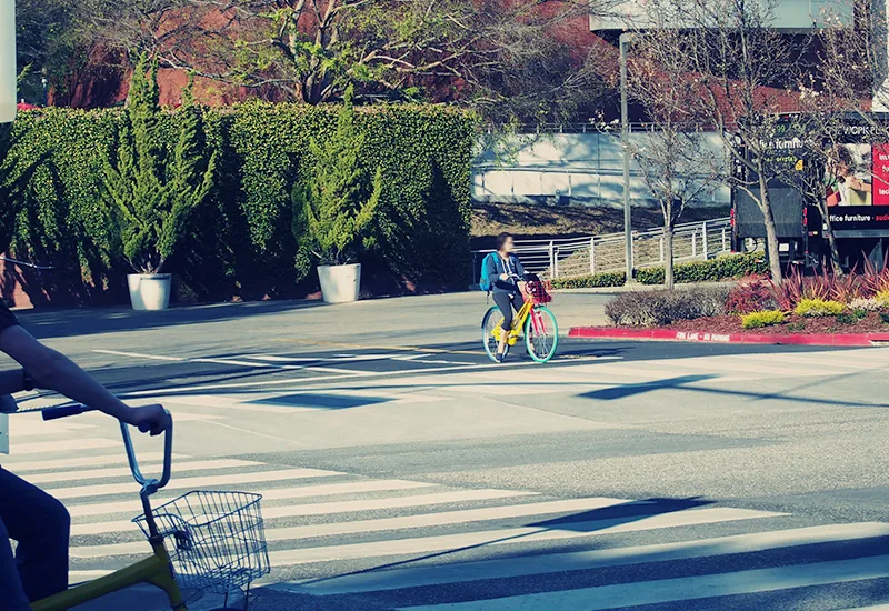 Cycliste sur un vélo Google traversant une rue du campus de Mountain View