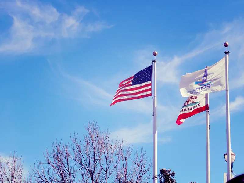 Drapeaux américain et californien flottant au-dessus de Fisherman's Wharf