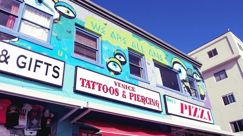 Façade colorée d'un salon de tatouage et d'une pizzeria sur le boardwalk de Venice Beach