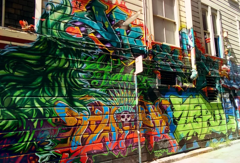 Graffitis verts et colorés sur une façade en bois de Mission District