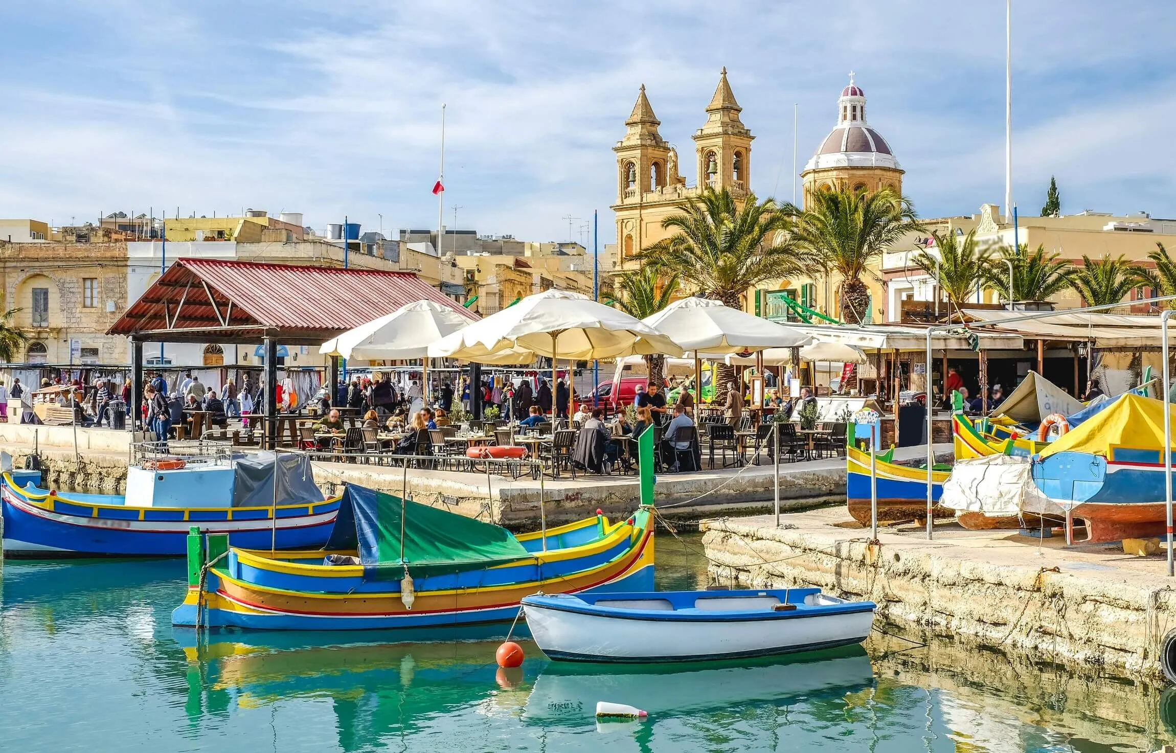 Port de Marsaxlokk à Malte avec ses barques luzzu colorées et l'église Notre-Dame-de-Pompéi