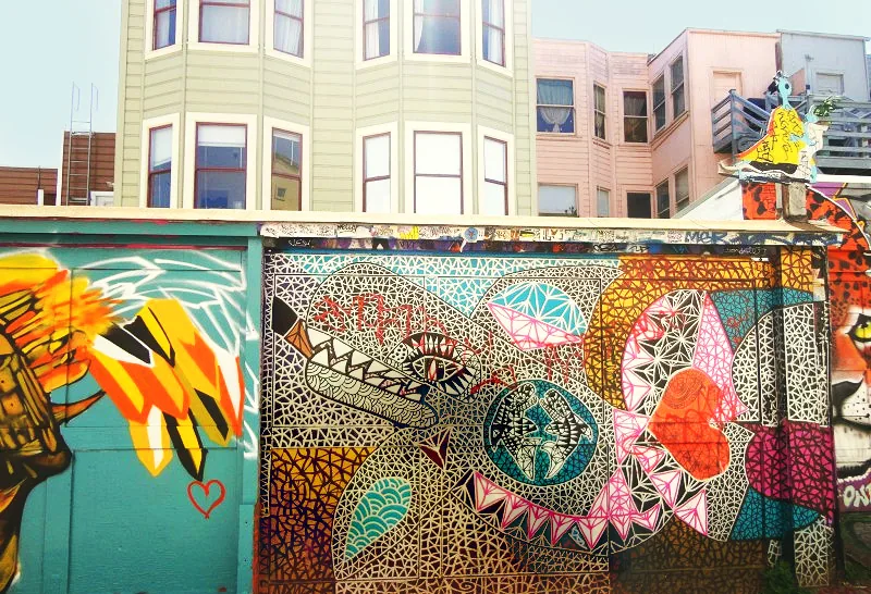 Mur peint de motifs graphiques au pied d'immeubles de Mission District