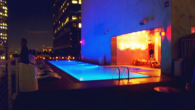 Piscine éclairée en bleu sur un rooftop de Downtown LA la nuit
