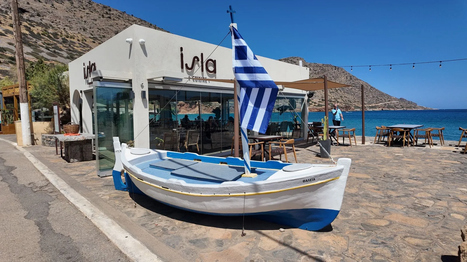 Taverne et barque traditionnelle au bord de l'eau à Plaka