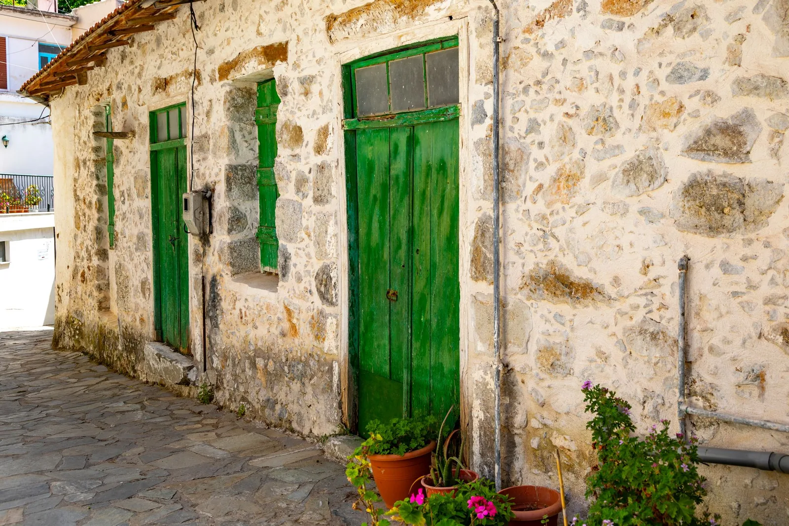 Maison en pierre aux portes vertes dans le village de Spili