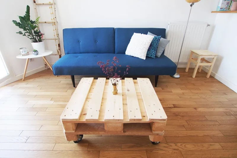 Table basse en palette de bois fait maison sur roulettes dans un salon