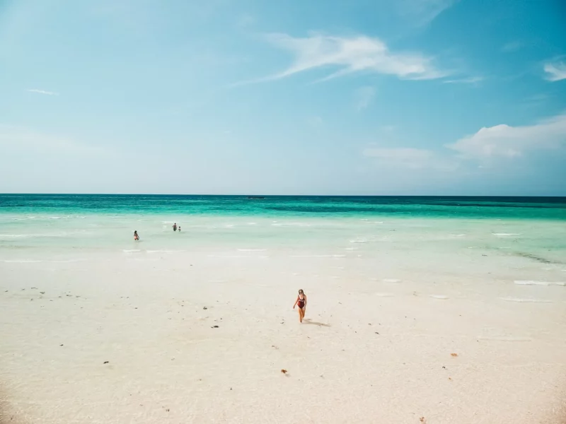 Voyageuse marchant sur une immense plage de sable blanc à Grand Bahama Island