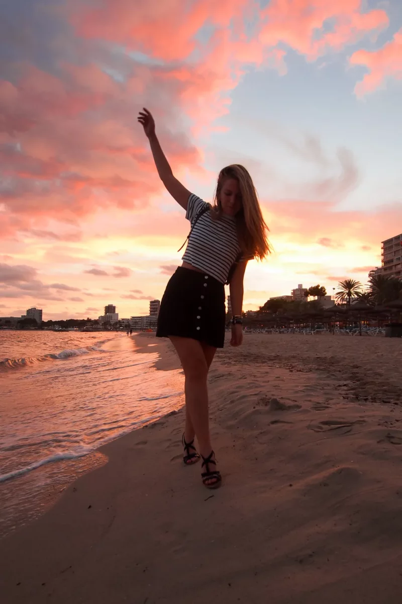 Voyageuse sur le sable au coucher du soleil sur une plage de la baie de Palma à Majorque